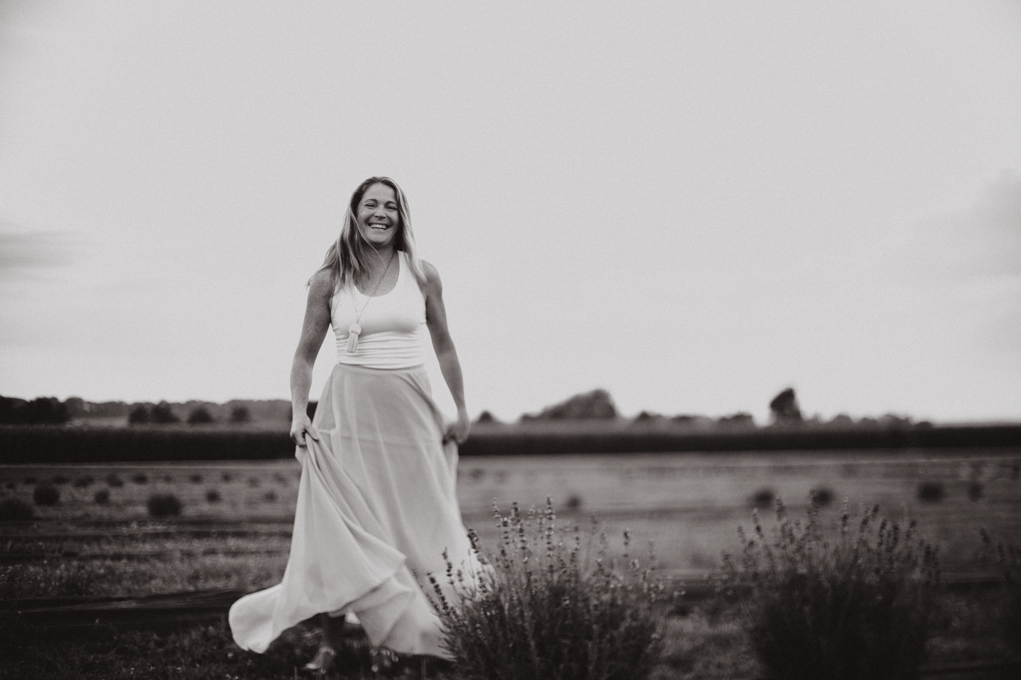 Red headed woman in yellow skirt at sunset in a lavender field.